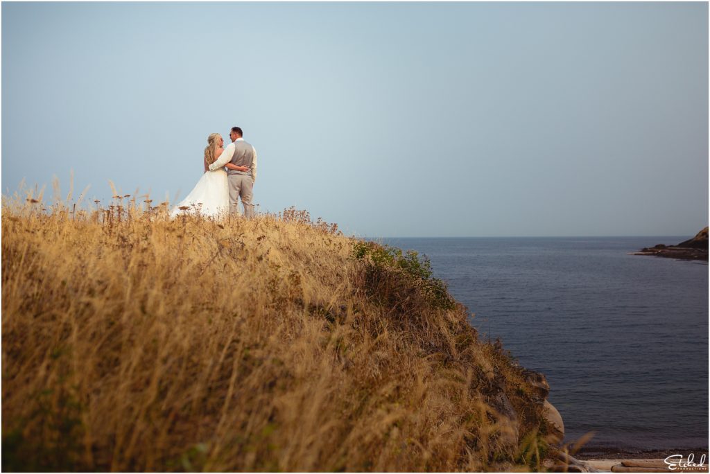 bride and groom in tall grass on cliff