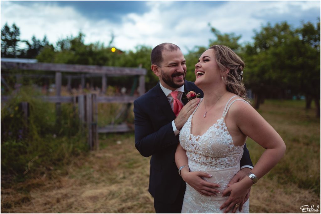 couple laughs in field at Merridale Cidery wedding