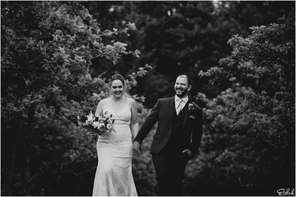candid black and white of wedding couple walking at Merridale Cidery